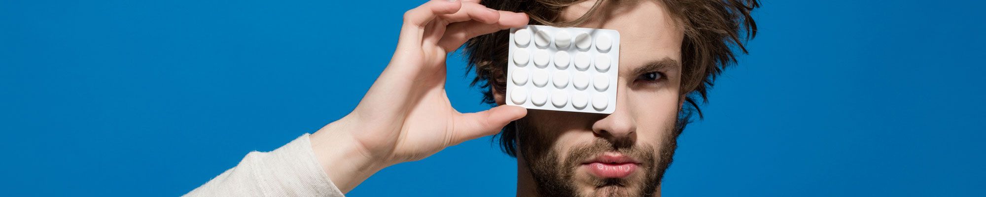 Man holding up hair loss treatment pills