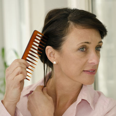 Middle aged woman combing her hair