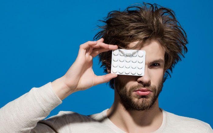 Man holding up hair loss treatment pills